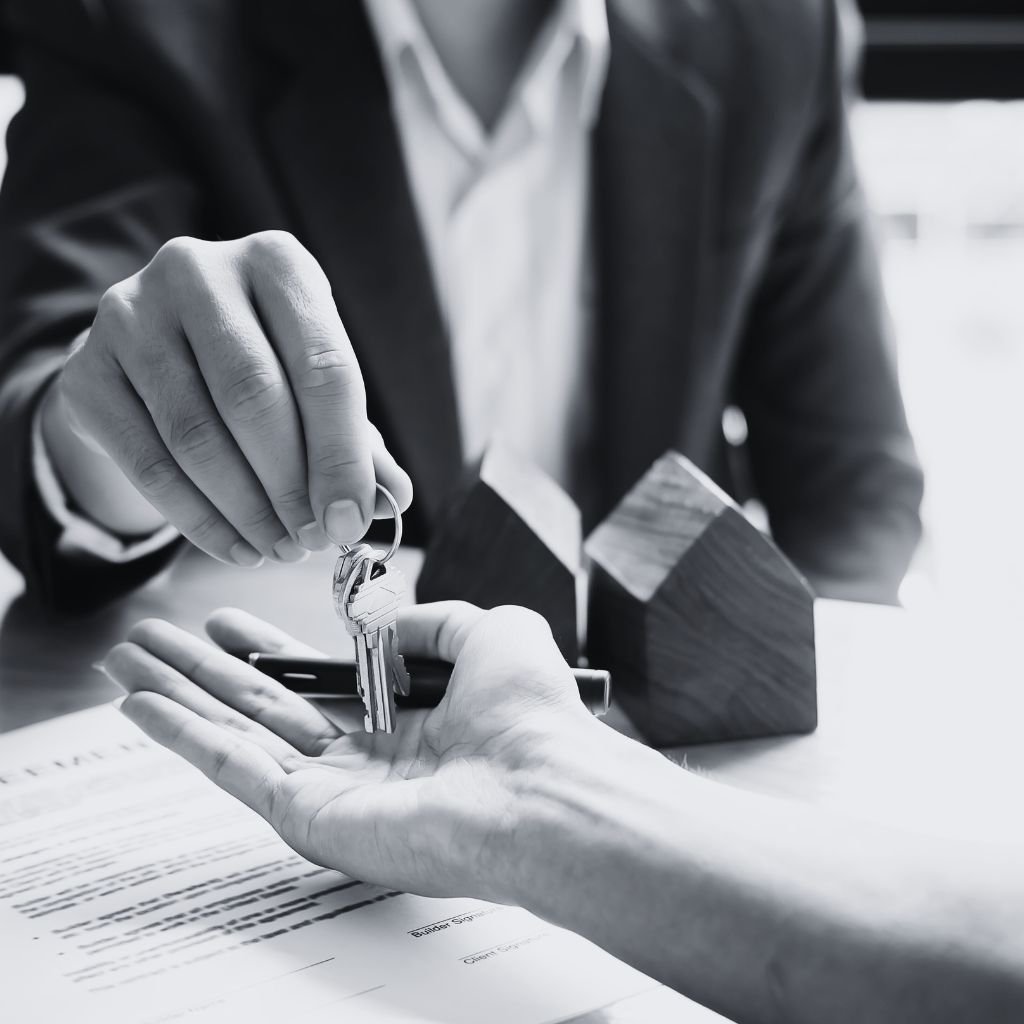 Gestor inmobiliario dándole las llaves a los inquilinos de la propiedad